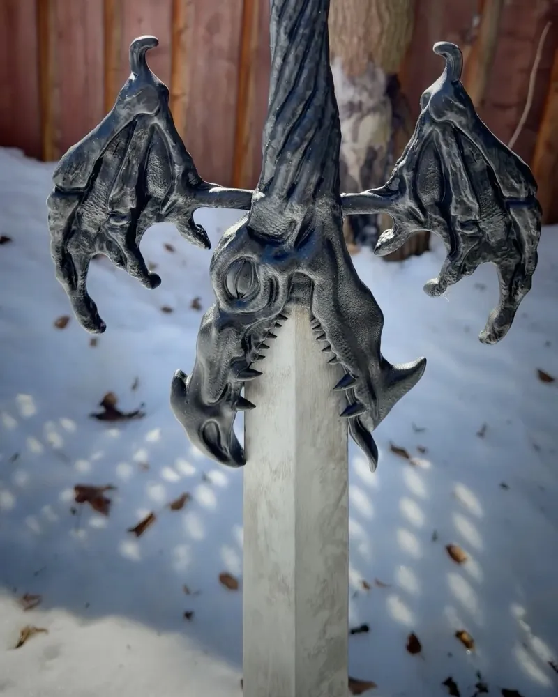 The finished Alastor sword, painted silver and black, standing in the snow